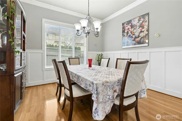 a kitchen with stainless steel appliances granite countertop a stove top oven a dining table and chairs