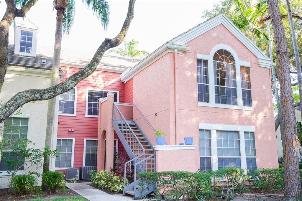 a front view of a house with a yard and potted plants