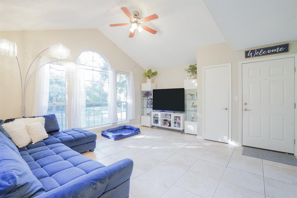1011 Crystal Way, Unit P Delray Beach, FL 33444 - Photo 2 of 28 a living room with furniture a flat screen tv and a large window