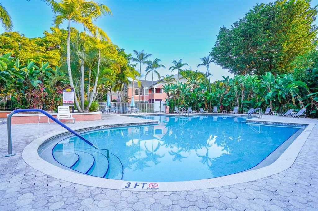 1011 Crystal Way, Unit P Delray Beach, FL 33444 - Photo 23 of 28 a view of a swimming pool with a yard