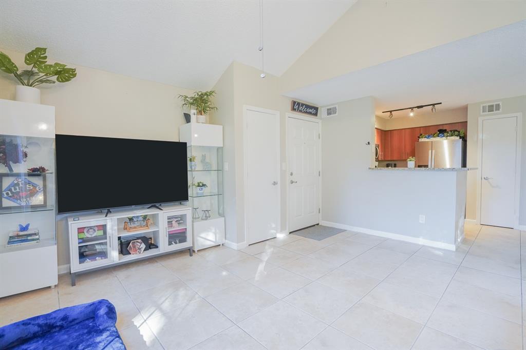 1011 Crystal Way, Unit P Delray Beach, FL 33444 - Photo 3 of 28 an empty room with furniture and a flat screen tv