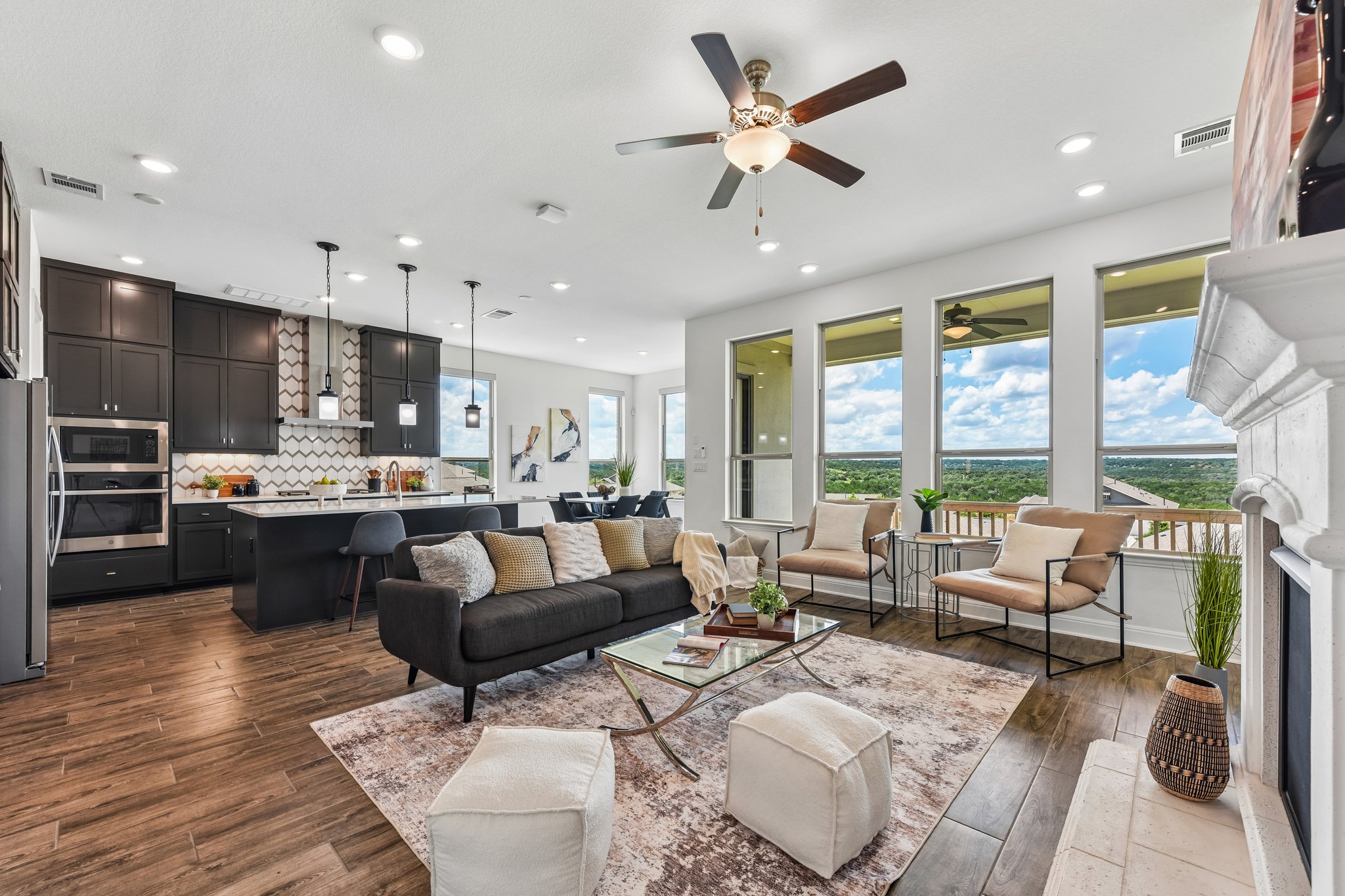 19113 Freeman Circle Austin, TX 78738 - Photo 1 of 37 An open concept living area boasts a modern kitchen, inviting seating, and panoramic outdoor views.
