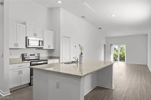 a kitchen with stainless steel appliances granite countertop a sink stove and cabinets