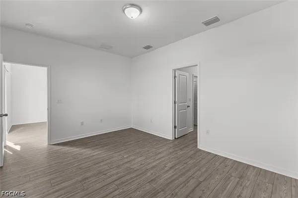 an empty room with wooden floor and mirror