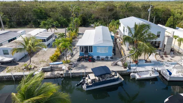 a view of pool with lawn chairs and plants