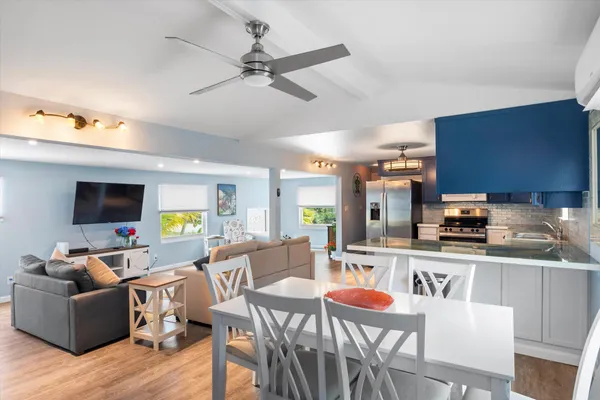 a kitchen with stainless steel appliances kitchen island granite countertop a dining table and chairs