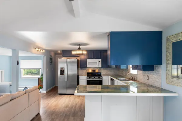 a kitchen with stainless steel appliances granite countertop a sink a stove and a refrigerator