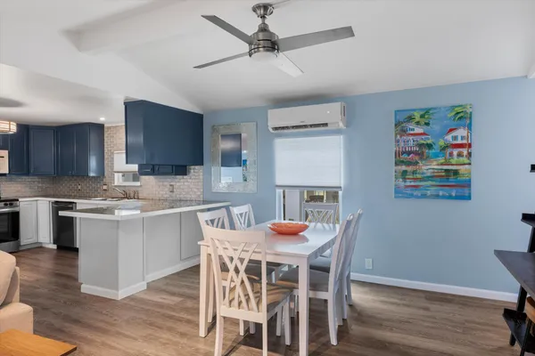 a kitchen with a table chairs refrigerator and microwave