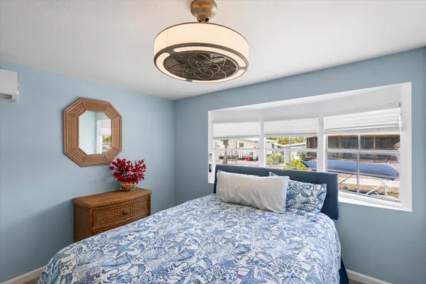 a bedroom with bed and a large window