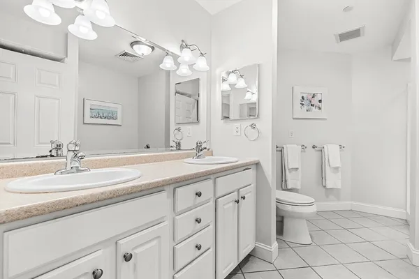 a bathroom with a double vanity sink mirror and toilet