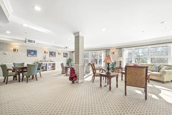 a dining room with furniture and a floor to ceiling window