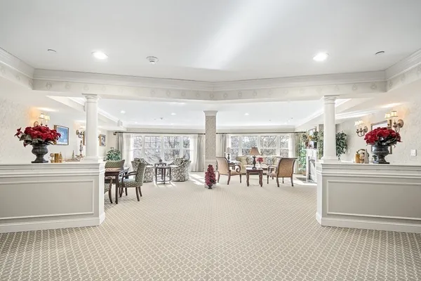 a view of a dining room with furniture a chandelier and a rug