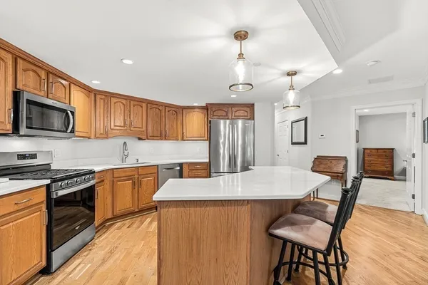 a kitchen with granite countertop a table chairs microwave and cabinets