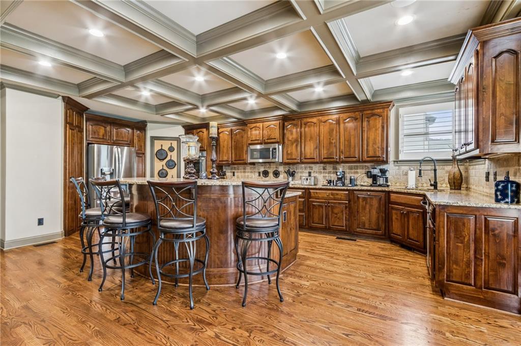 2391 Hopehaven Way Hoschton, GA 30548 - Photo 17 of 87 a kitchen with stainless steel appliances wooden floors wooden cabinets dining table and chair