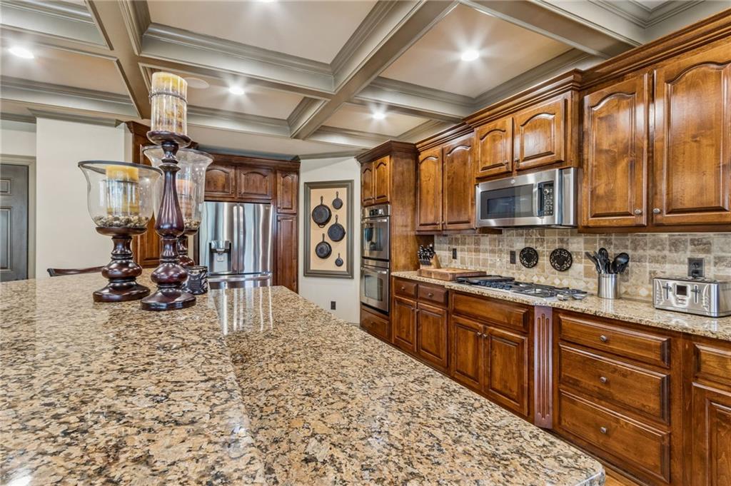 2391 Hopehaven Way Hoschton, GA 30548 - Photo 28 of 87 a kitchen with stainless steel appliances granite countertop a stove sink and cabinets