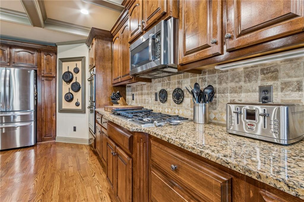 2391 Hopehaven Way Hoschton, GA 30548 - Photo 30 of 87 a kitchen with stainless steel appliances granite countertop a stove and a refrigerator