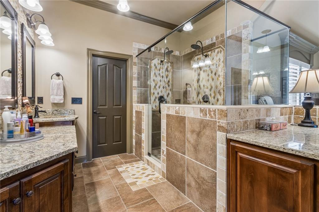 2391 Hopehaven Way Hoschton, GA 30548 - Photo 39 of 87 a bathroom with a granite countertop sink a mirror and a shower