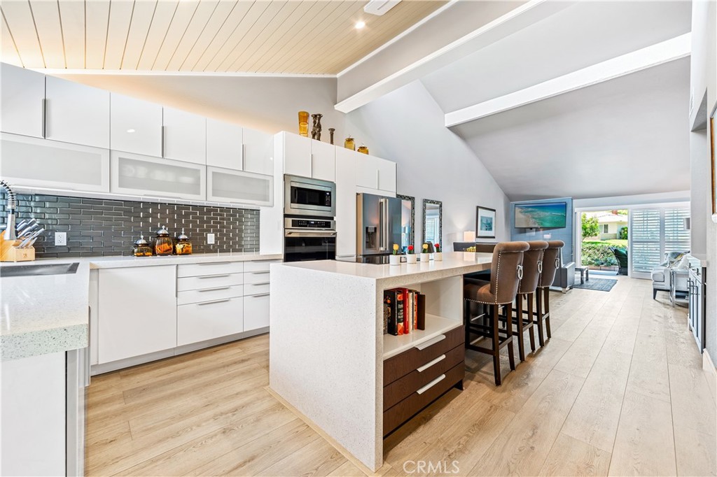 17294 Citron Irvine, CA 92612 - Photo 2 of 26 a kitchen with stainless steel appliances kitchen island granite countertop a table chairs in it and a window