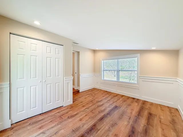 a view of a kitchen with refrigerator and wooden floor