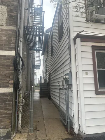 a view of a white house with a small yard and large tree