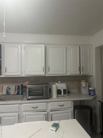 a room with painting on the wall and a refrigerator