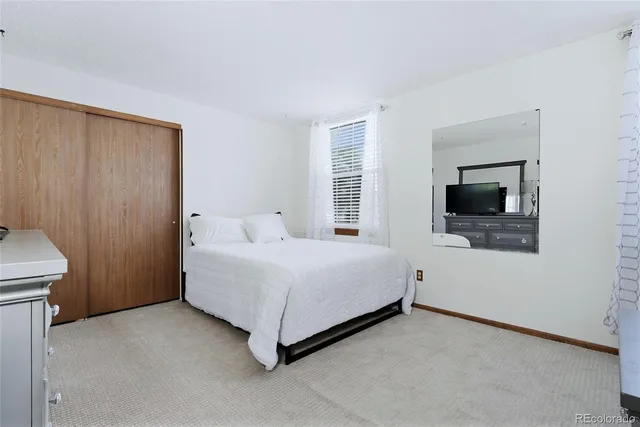 a spacious bedroom with a bed and a flat screen tv