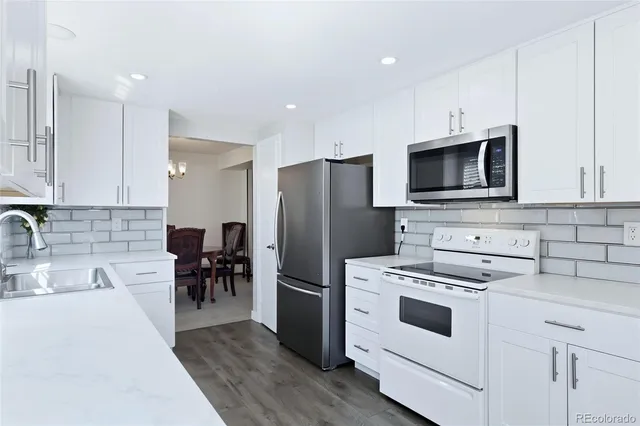 a kitchen with kitchen island white cabinets appliances and wooden floor