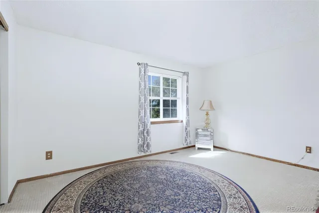 a view of a bedroom with a bed and a window