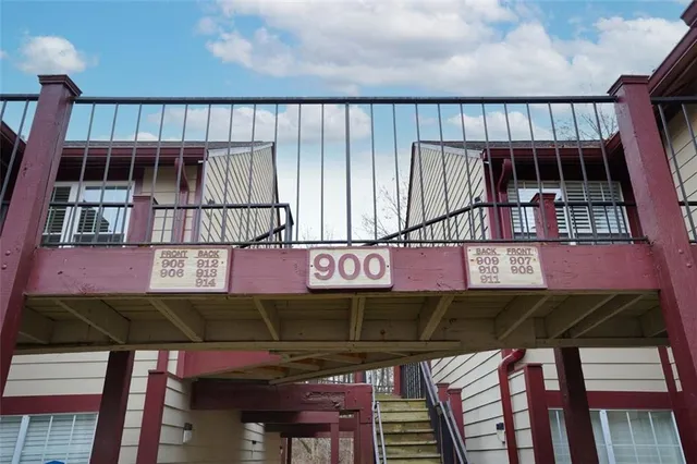a view of a brick house with large windows and a bench