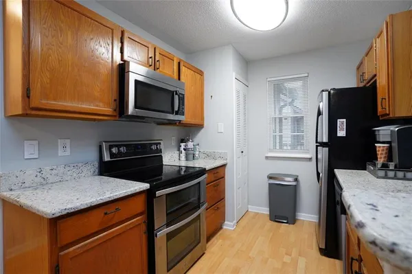 a kitchen with stainless steel appliances granite countertop a stove a sink and a microwave