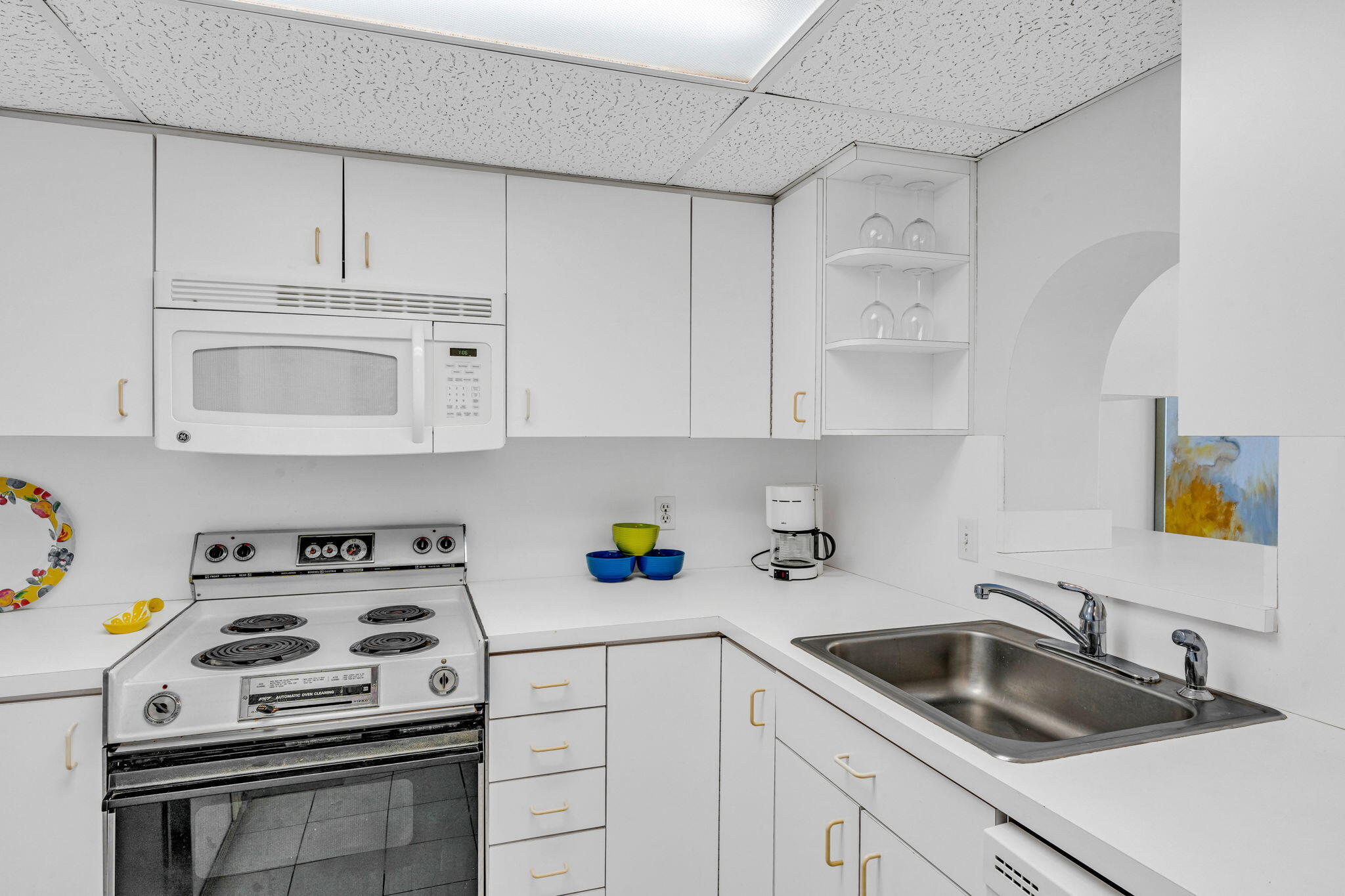 2000 Coco Plum Drive, Unit 1202 Marathon, FL 33050 - Photo 12 of 44 a kitchen with cabinets a stove a sink and a counter space