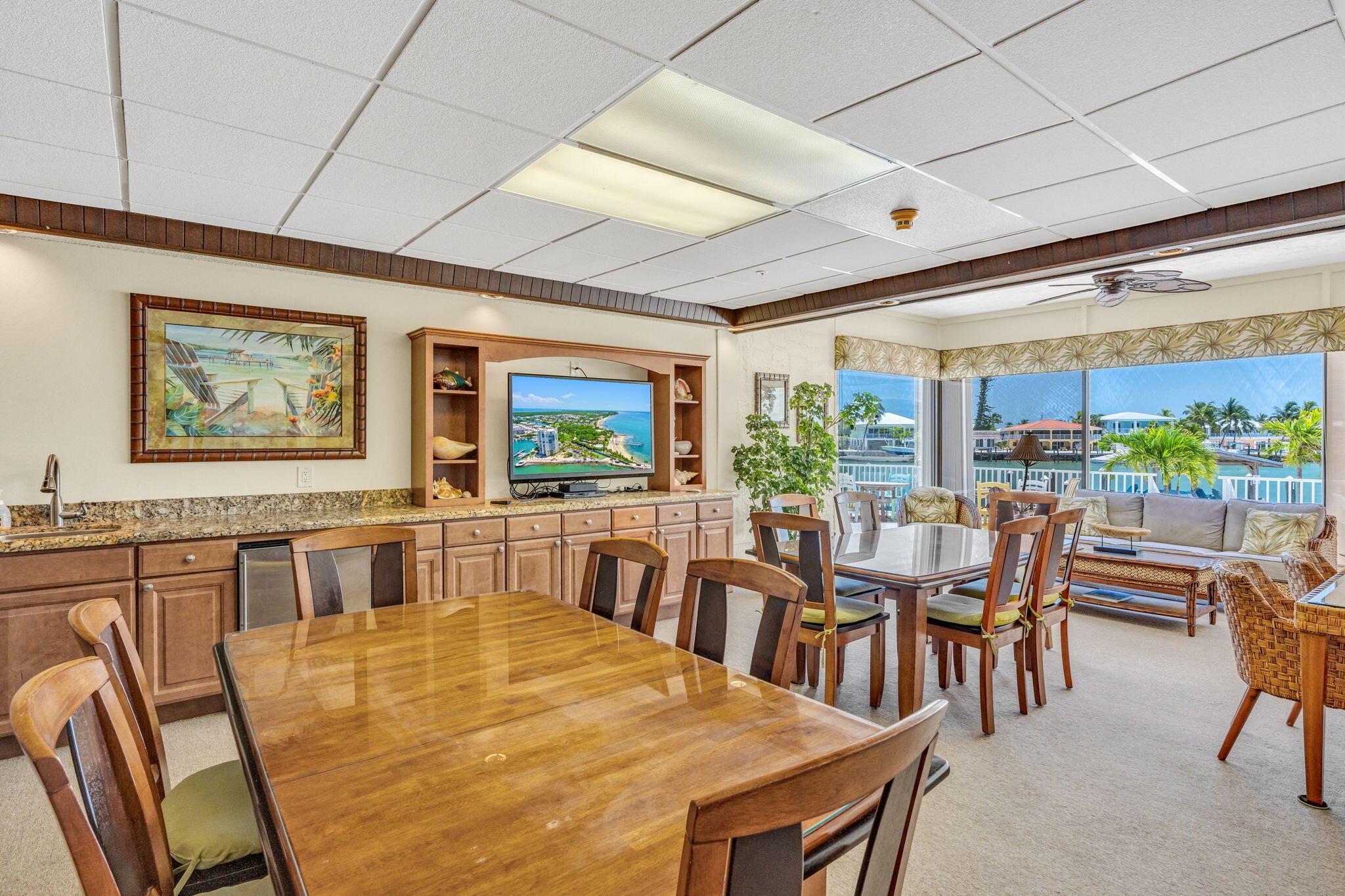 2000 Coco Plum Drive, Unit 1202 Marathon, FL 33050 - Photo 29 of 44 a dining room with furniture a floor to ceiling window and wooden floor
