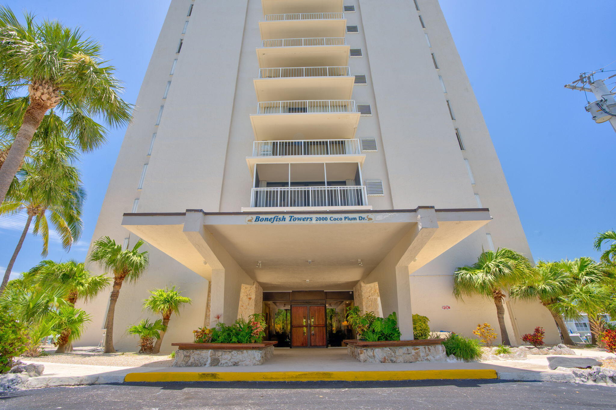 2000 Coco Plum Drive, Unit 1202 Marathon, FL 33050 - Photo 4 of 44 a view of a building with a yard and plants