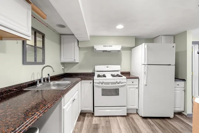 a spacious bedroom with a bed and wooden floor
