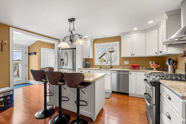 a large kitchen with stainless steel appliances granite countertop a stove a sink and a refrigerator