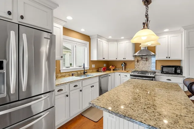 a kitchen with stainless steel appliances granite countertop a sink stove and refrigerator