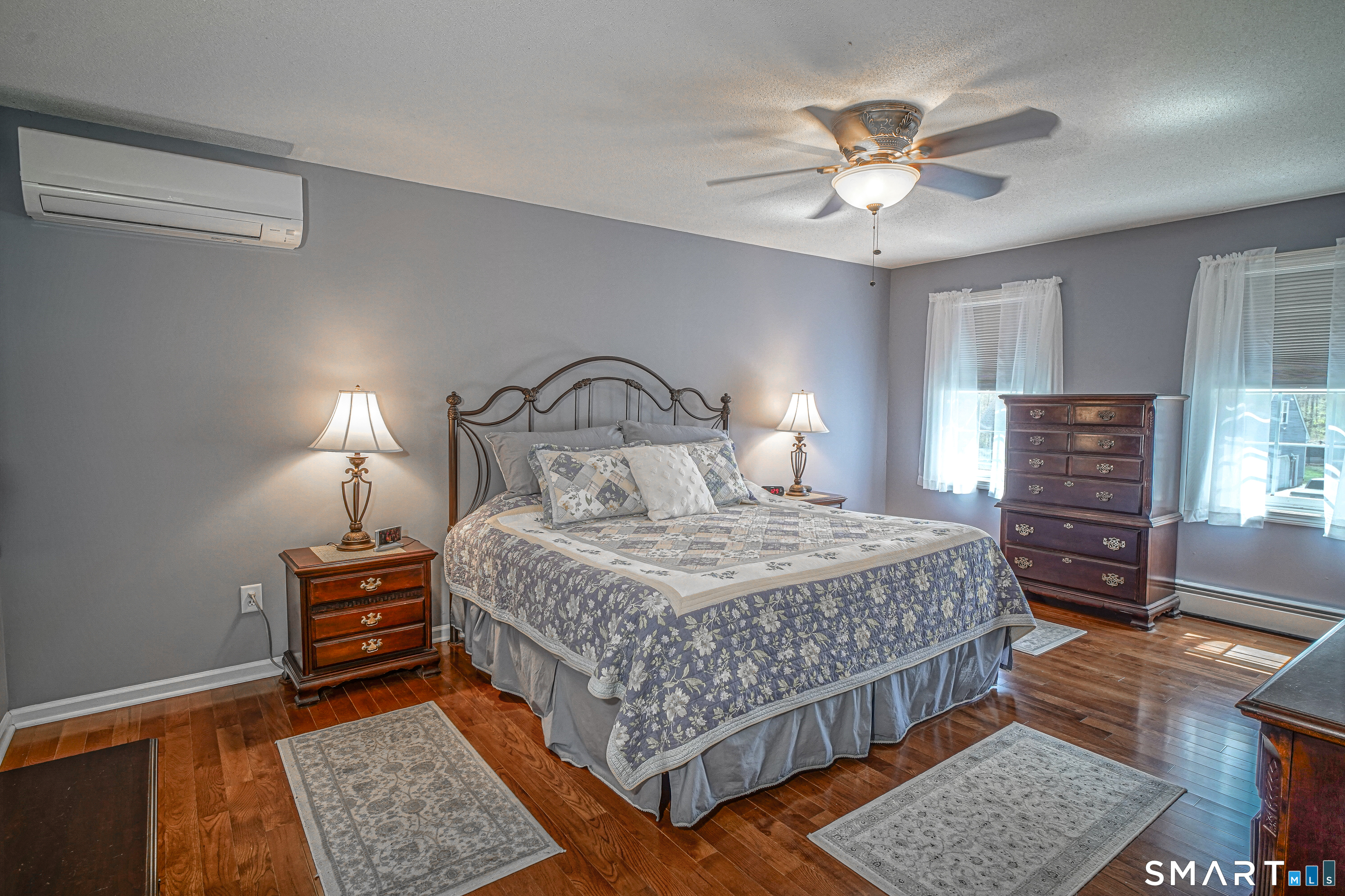 20 Stephen Court Prospect, CT 06712 - Photo 17 of 39 The primary bedroom features hardwood floors, a split-wall AC unit, and a ceiling fan.