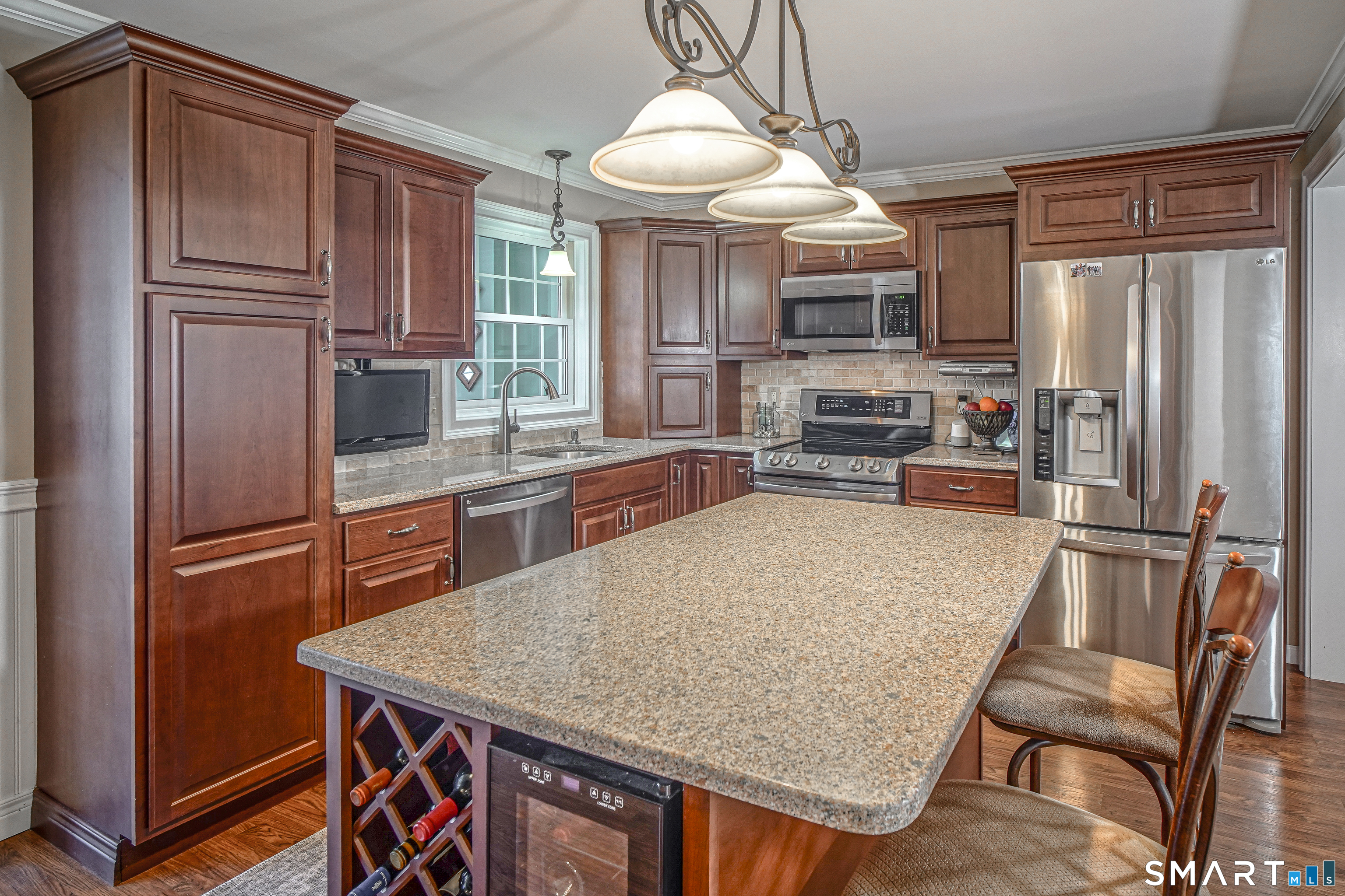 20 Stephen Court Prospect, CT 06712 - Photo 7 of 39 The island includes a wine rack and a refrigerator.