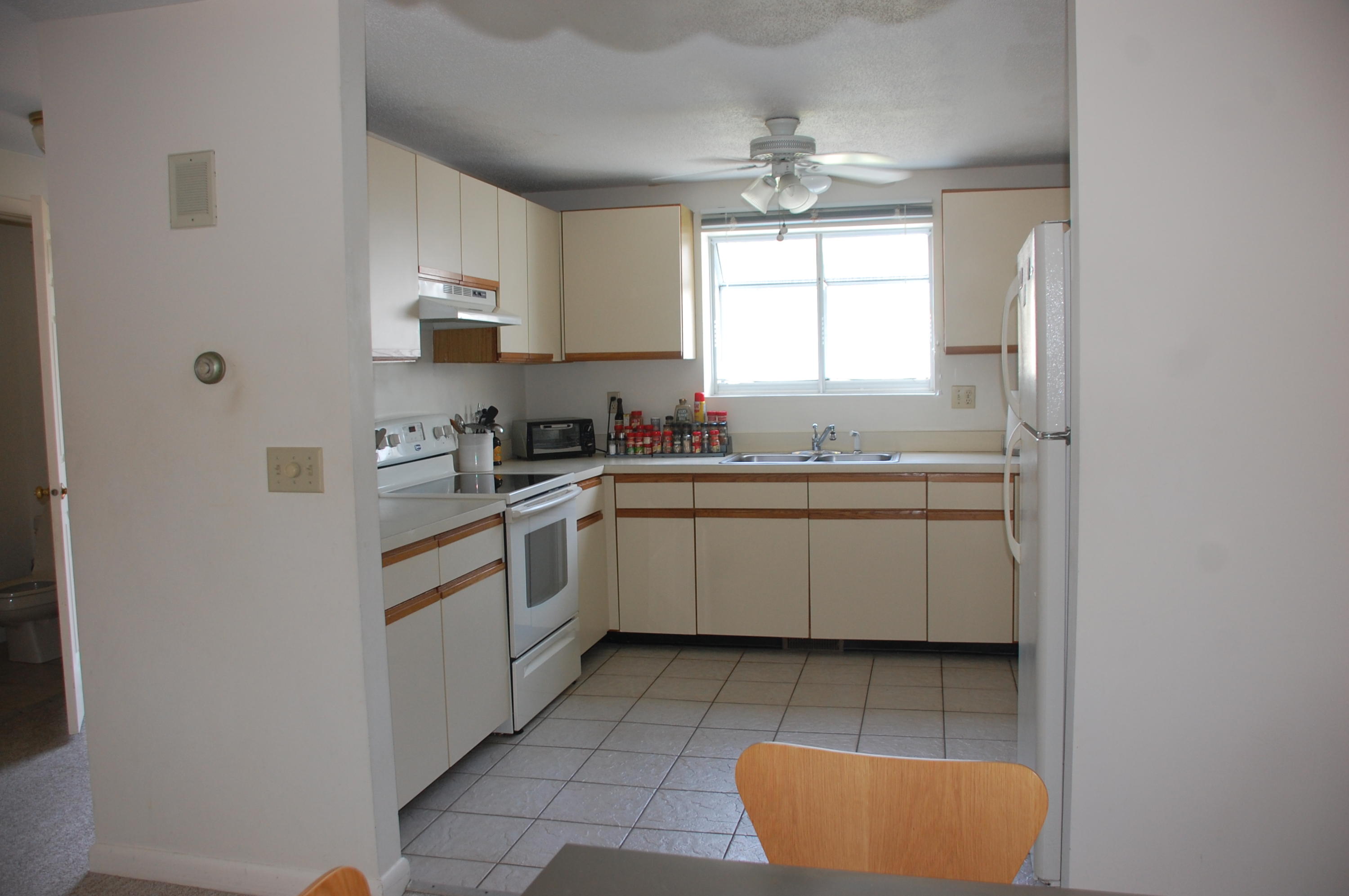 156 Shellback Way, Unit X156 Mashpee, MA 02649 - Photo 3 of 7 a kitchen with a sink window and cabinets