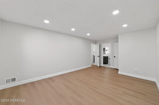 a view of empty room with wooden floor and window