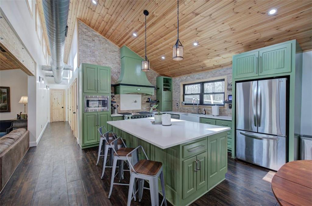 675 McGee Bend Road Southwest Cave Spring, GA 30124 - Photo 6 of 71 a kitchen with stainless steel appliances granite countertop a refrigerator a sink dishwasher a stove and a dining table with wooden floor