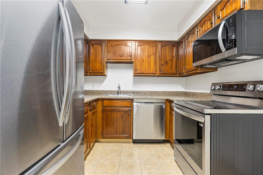307 South Dithridge Street, Unit 11 Pittsburgh, PA 15213 - Photo 20 of 33 a kitchen with stainless steel appliances granite countertop a stove a sink and a microwave