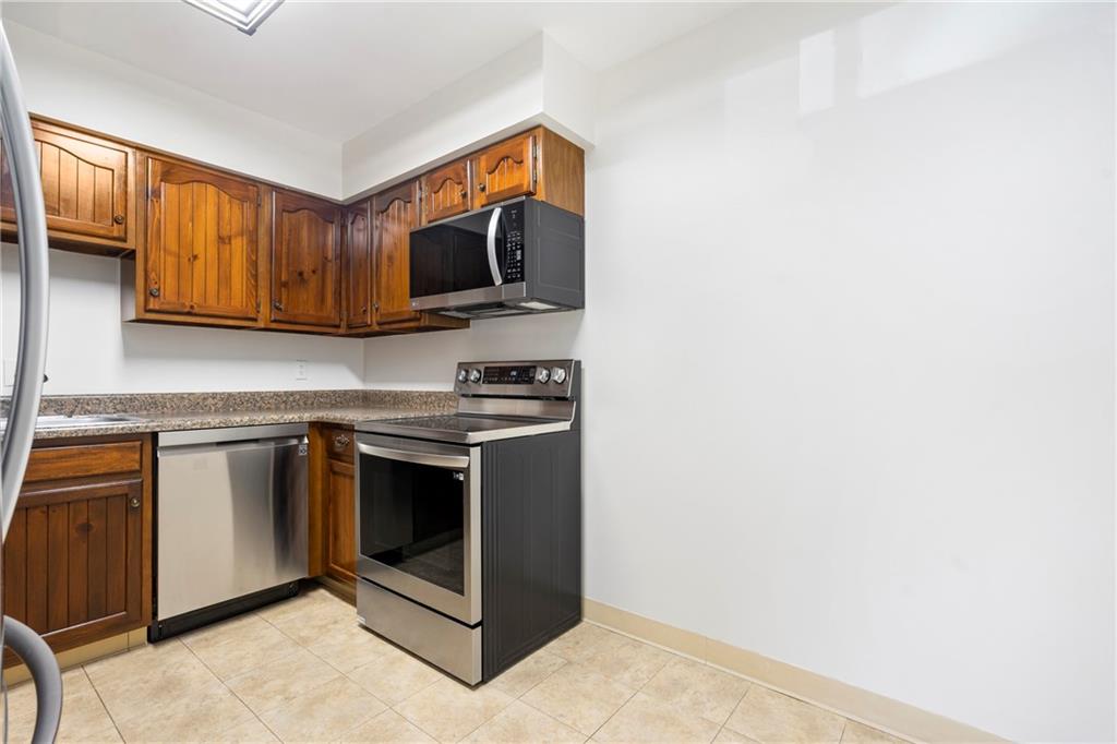 307 South Dithridge Street, Unit 11 Pittsburgh, PA 15213 - Photo 24 of 33 a kitchen with stainless steel appliances wooden cabinets and a stove top oven