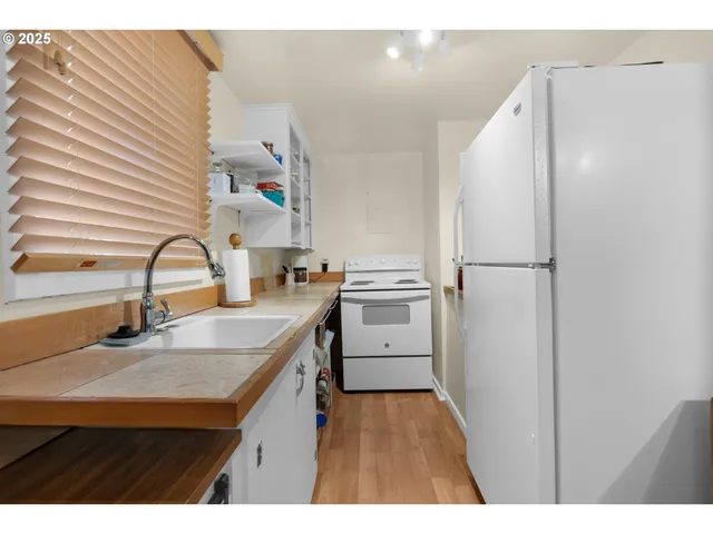 a kitchen with a sink refrigerator and cabinets