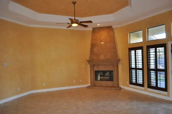 a view of an empty room with a fireplace and a window
