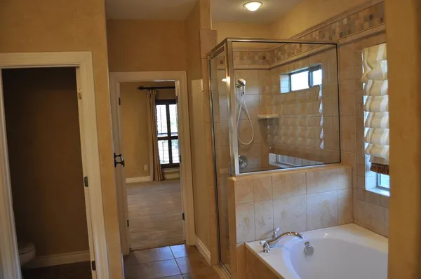 a bathroom with a tub shower vanity and a sink