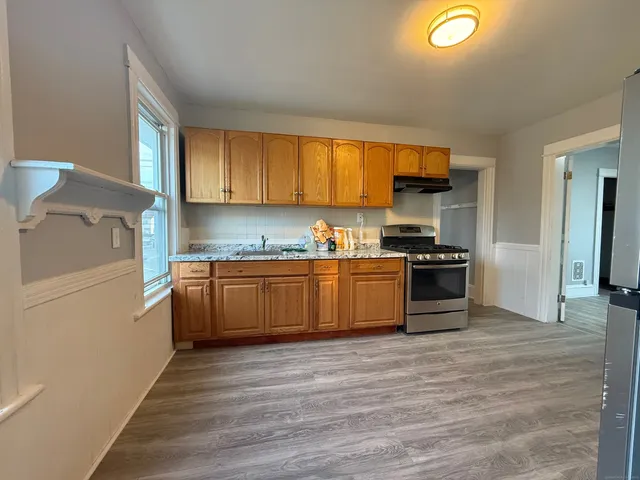 a kitchen with a sink window and stainless steel appliances