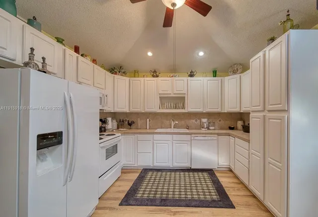 a kitchen with a sink a refrigerator and cabinets