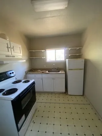 a kitchen with a stove a sink and a refrigerator