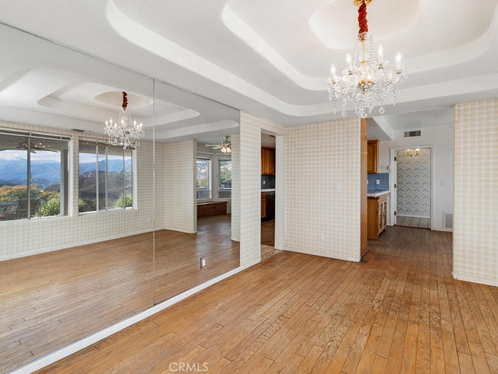6455 Rainbow Heights Road Fallbrook, CA 92028 - Photo 14 of 63 a view of an empty room with wooden floor and a kitchen